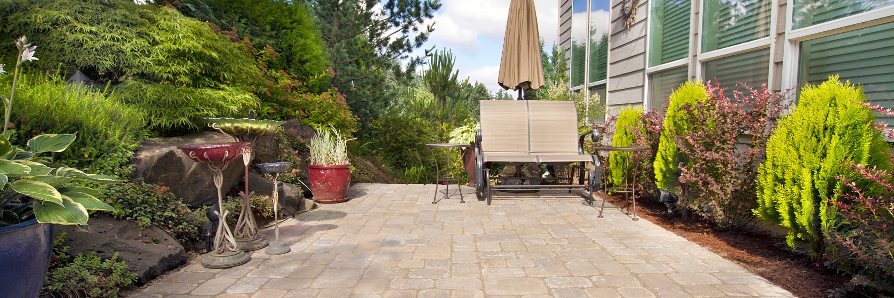 Paver patio with outdoor seating beside a house