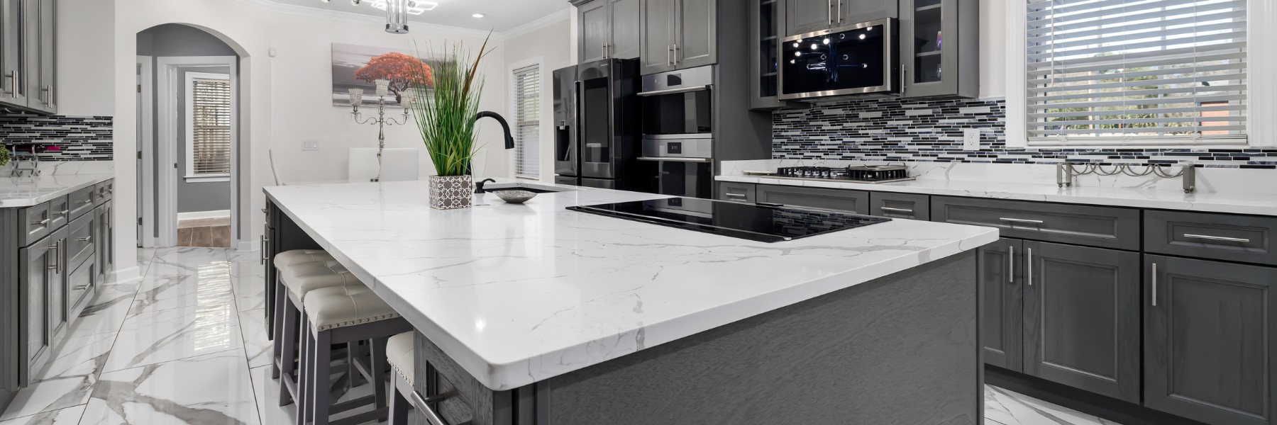 Remodeled kitchen with marble island and gray cabinets