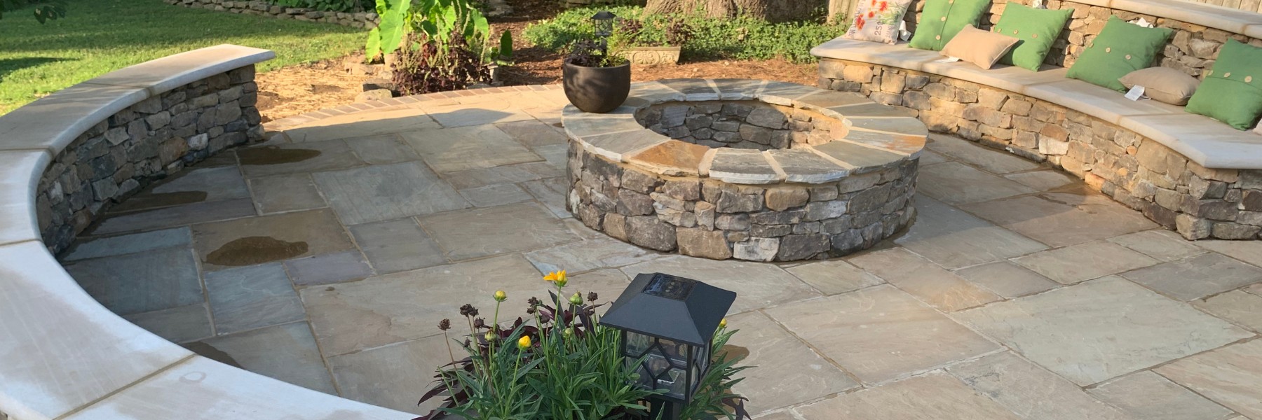 Stone patio with built-in seating wall and fire pit