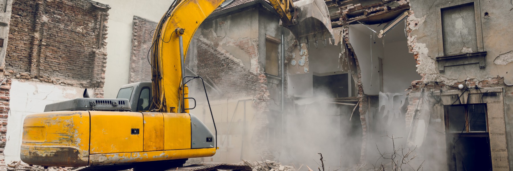 Excavator demolishing a brick building